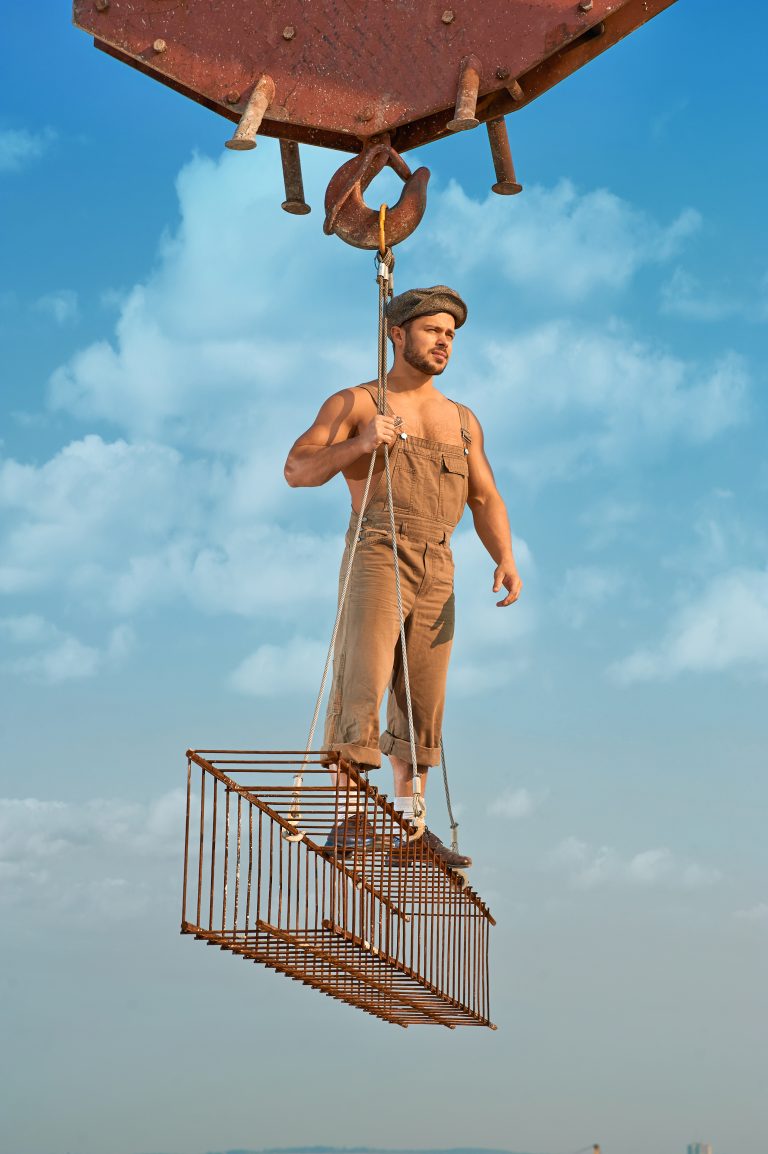 Man standing on iron construction over city.